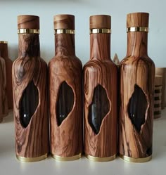 four wooden bottles are lined up on a table