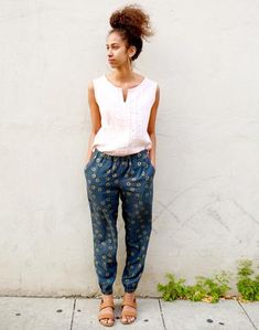 a woman standing in front of a white wall