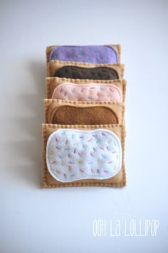 a wallet with five different colors and designs on the front, sitting on a white surface