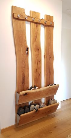 a wooden bench with rocks in it on top of a hard wood floor next to a white wall