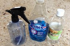 two bottles of dawn and one bottle of mouthwash are on the counter with a black hand held soap dispenser