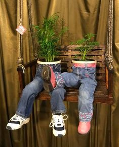 a person sitting on a swing with plants in their feet