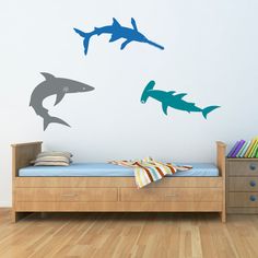 three shark wall decals on a white wall in a child's room with wood flooring