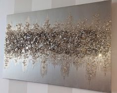 a large silver painting hanging on the wall