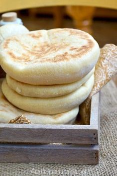 some pancakes are stacked in a wooden box on a burlocksed tablecloth