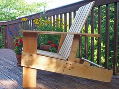 a wooden bench sitting on top of a wooden deck next to flowers and potted plants