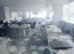 blurry image of an office with desks and computers in it's cubicle