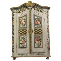 an ornately decorated armoire with flowers and leaves on the front, against a white background