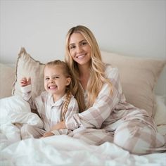 A smiling woman with long blonde hair and a young girl, both wearing matching beige plaid pajamas, sit together on a bed with white bedding and light beige pillows. Pajamas Cozy, Kids Plaid, Plaid Pajama, Adult Pajamas, Sock Booties, Holiday Plaid, Plaid Pajamas, Modal Fabric, Perfect Family