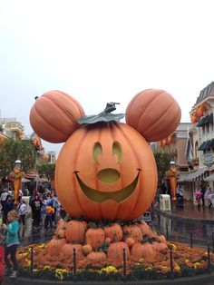 a mickey mouse pumpkin statue in the middle of a street