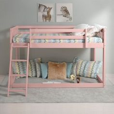 a pink bunk bed sitting next to a wall with pictures on the wall above it