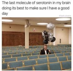 a man is sitting in an auditorium with balloons