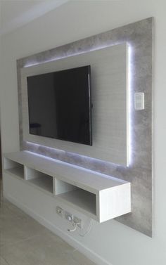 a flat screen tv mounted to the side of a wall in a room with white walls