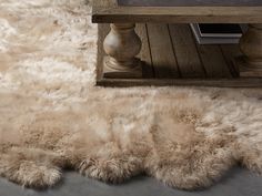 a sheepskin rug on the floor next to a table