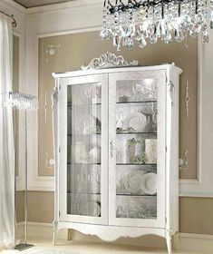 a white china cabinet with glass doors in a room