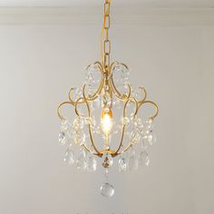 a chandelier hanging from the ceiling in a room with white walls and flooring