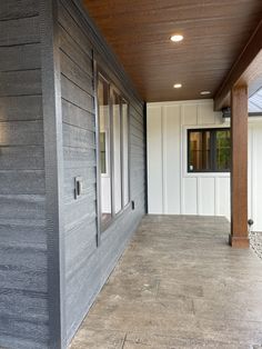 an empty porch with wood paneling on the side and white siding on the wall