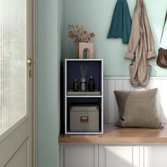 a shelf with some items on top of it next to a white door and window