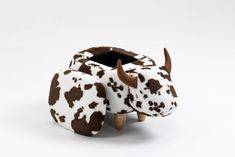 a brown and white cow toy sitting on top of a table