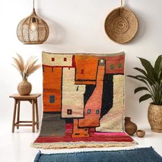 a colorful rug is on the floor next to some potted plants and other decorative items