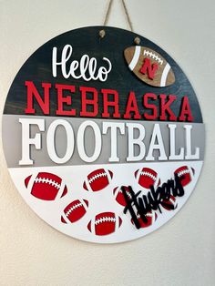 a sign that says hello, nebraska football on it and some balls hanging from the wall