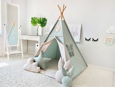 a child's teepee tent in the corner of a room with white walls