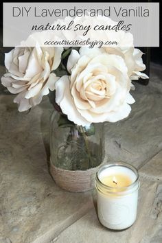 a jar filled with white flowers sitting on top of a table next to a candle