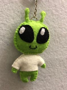 a keychain with a green and white stuffed animal hanging from it's side