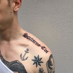 a man with an anchor and compass tattoo on his chest