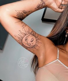 a woman with sun and moon tattoos on her arm, behind her head is a clock