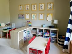 a child's playroom with toys, desks and pictures on the wall