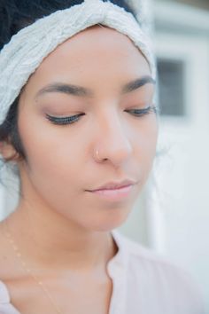 a woman with her eyes closed wearing a headband