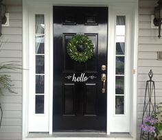 a black front door with a wreath on it