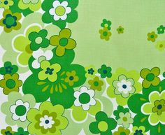 a green and white flowered fabric with small flowers on the bottom half of it