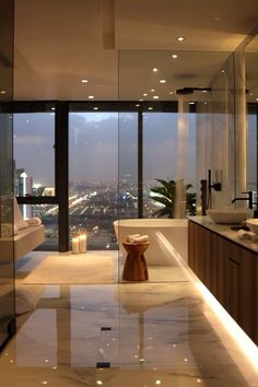 a modern bathroom with large windows overlooking the city lights and skyscrapers in the distance