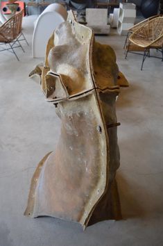 a wooden sculpture sitting on top of a cement floor