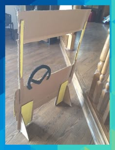 an open cardboard box sitting on top of a wooden floor next to a stair case