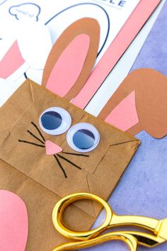 a paper bag with scissors on it and some bunny ears cut out to look like an easter bunny