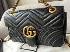 Overview Gucci GG Marmont small shoulder bag in black matelasse leather with gold hardware. This small Marmont bag has a softly structured shape and an oversized flap with GG hardware and heart detail on the back. The sliding chain can be multiple ways either doubled up or lengthened. Effortlessly chic and sophisticated, this style can be both with a casual outfit or for evening wear. Suitable for both event or occasion wear and ideal for those who prefer a cross body option. Features Black Mate Gg Marmont Small Shoulder Bag, Gucci Gg Marmont, Gg Marmont, Small Shoulder Bag, Diaper Backpack, Casual Backpack, Casual Outfit, Evening Wear, Brunei