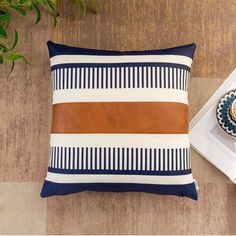 a brown and white pillow sitting on top of a wooden floor next to a plate