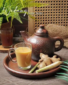 there is a tea pot and cup on the table next to some ginger, celery