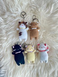 four crocheted keychains with cats on them