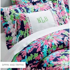 the monogrammed bedding is decorated with pink, blue and green florals