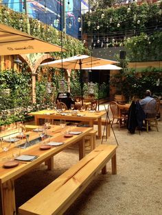 an outdoor dining area with tables and umbrellas set up for people to sit at