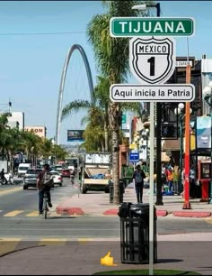 a street sign on the corner of tijuana and mexico with people walking by