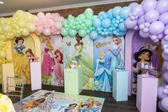 there are many balloons and princesses on the walls in this party decorationating area