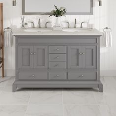 a bathroom vanity with two sinks and a large mirror above it, all in grey