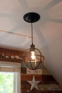 a light fixture hanging from the ceiling in a room with wood paneling and stars