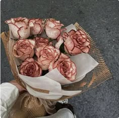 a person holding a bouquet of pink roses