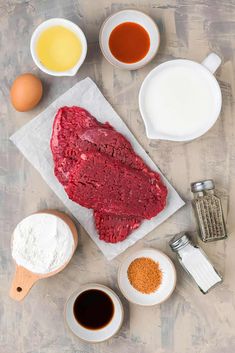 raw meat and ingredients laid out on a table